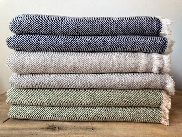 A stack of folded cashmere throws in muted colours